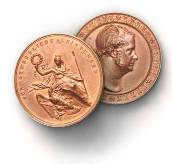 Zwei Kupfermünzen mit Prägungen sind nebeneinander zu sehen, eine zeigt einen Mann von der Seite, die andere eine Frau mit Adler.